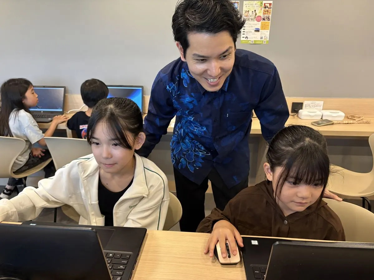 講師に見守られながらパソコンで作品づくりに取り組む子どもたち
